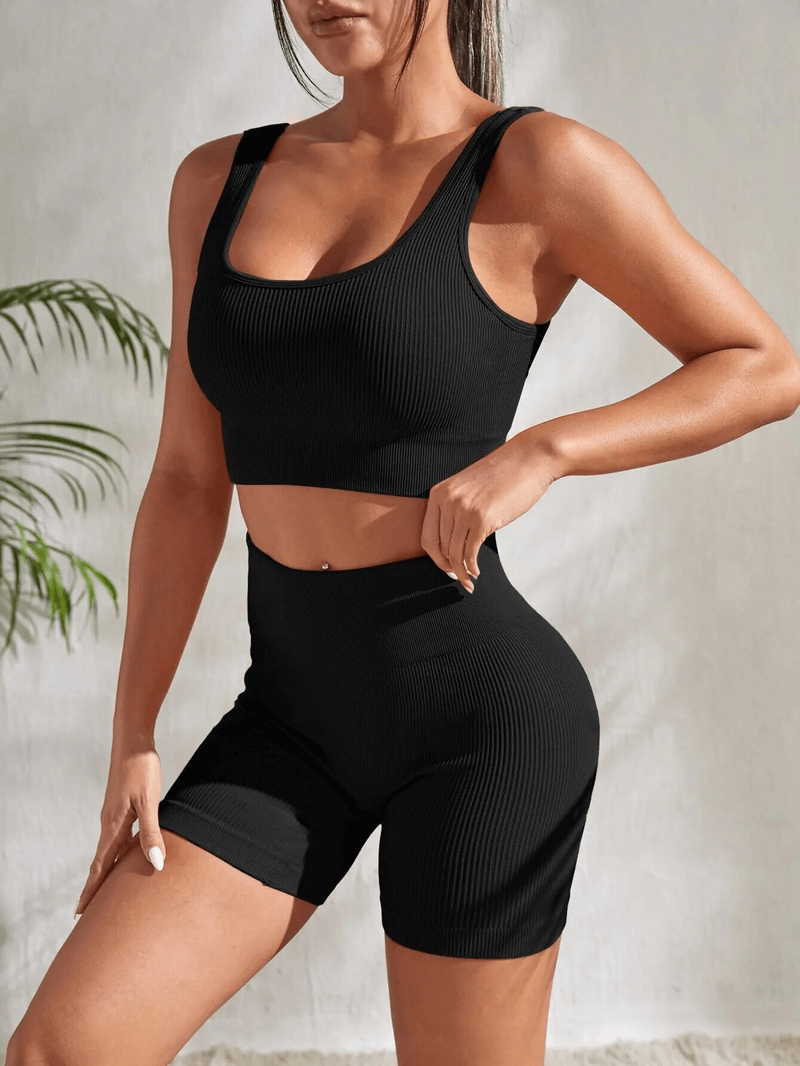 Seamless ribbed yoga crop top and high waist shorts set in black, quick-dry breathable fabric, designed for comfort and mobility during workouts.